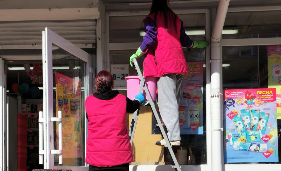people cleaning outside store