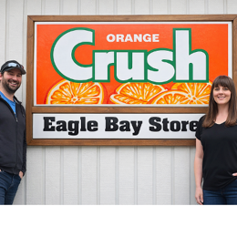 Eagle Bay owners in front of Crush sign