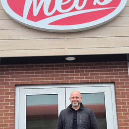 Unnamed owner stands in front of Mel's convenience store.