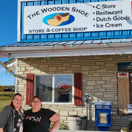 Owners of The Wooden Shoe standing outside their store.