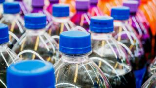 tops of pop bottles in a store
