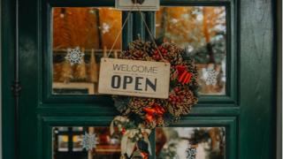 welcome open. sign board through the glass of store window.