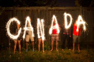 Kids writing Canada with sparklers