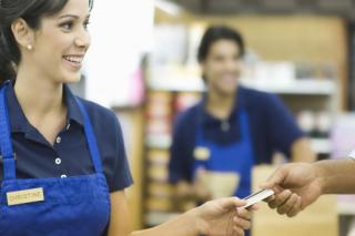 Closeup of a hand giving female employee loyalty card