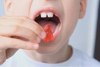 child putting a gummy bear in their mouth