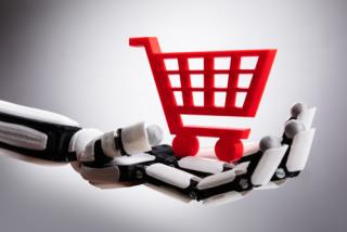 Close-up Of A Robotic Hand Holding Red Shopping Cart On Gray Background