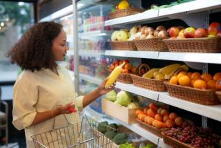 An african american woman buy a fruit and vegetable from refrigerator cold in food convenience store for eat at home