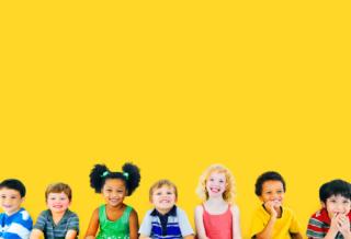 children smiling against a yellow background