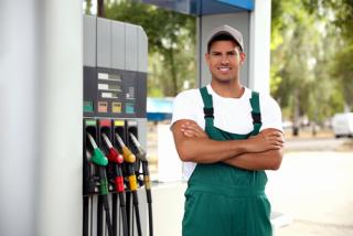 Worker in uniform at modern gas station