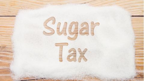 Close-up of sugar with text Sales Tax on weathered wood background