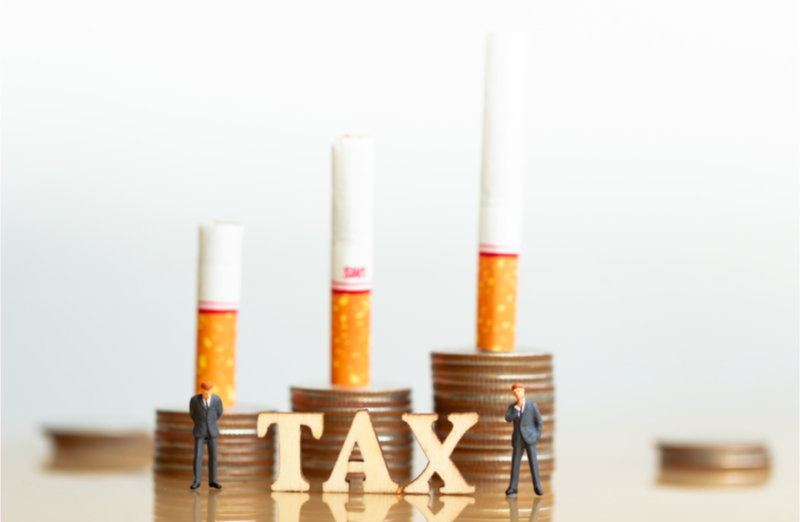 illustration with coins, cigarettes and the word tax