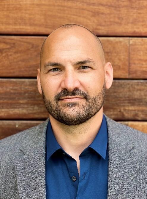 photo of Ian against a wood wall