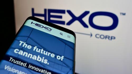 Smartphone with business website of Canadian cannabis company HEXO Corp on screen in front of top-left of logo.
