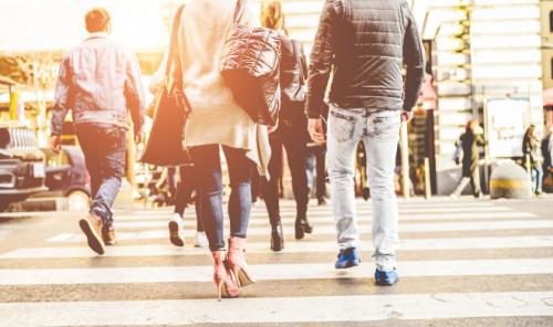 Crowd of people walking on zebra crossing street city center - Concept of modern, rushing, urban, city life, business, shopping - Focus on woman black bag