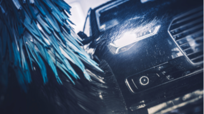 Car going through a wash with big brushes grazing its sides