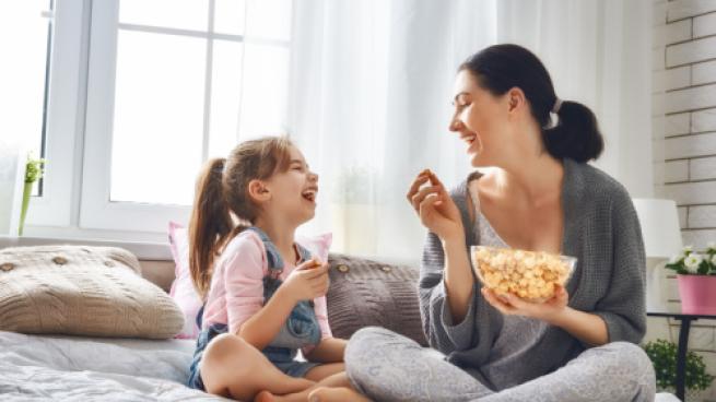 woman and child enjoying a bowl of popcorn