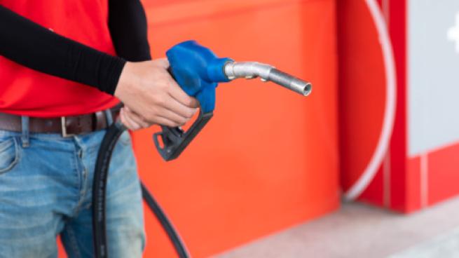 Man  hand holding nozzle to refuel the car