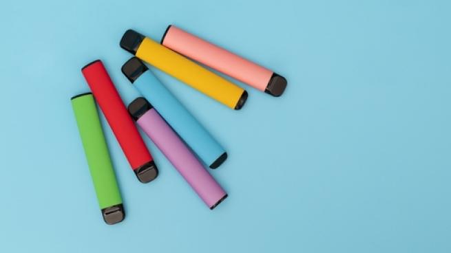 Multiple colourful vapes on a blue background.