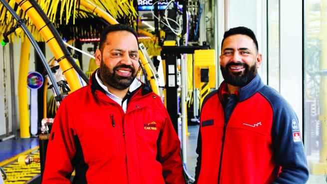 Tony Thind and Rozy in front of Klassic Car Wash's automatic carwash system.