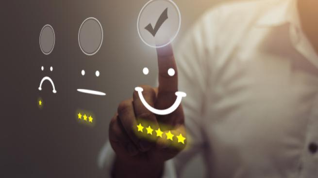 Person ranks customer satisfaction report with a smiley face and five stars.