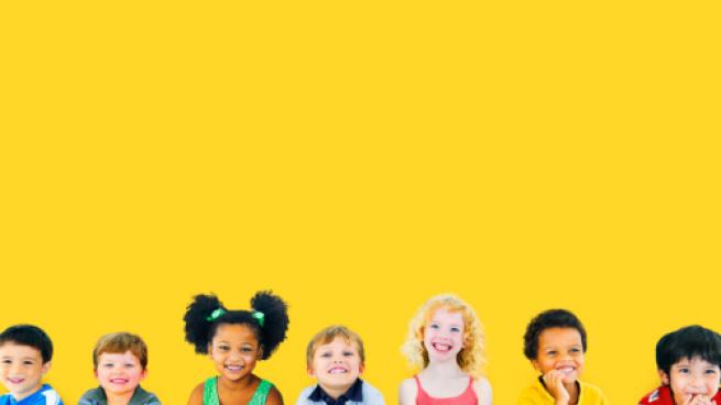 children smiling against a yellow background