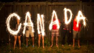 Kids writing Canada with sparklers