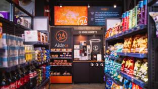 A retail food aisle with chips and soft drinks.