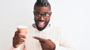 African american man with braids drinking take away coffee over isolated white background very happy pointing with hand and finger