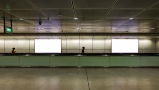 Edited visual for advertising billboard display: Pedestrians walking on moving walkway / travelator in train station. Blank billboards advertising space for mock up purpose; OOH ad placement.